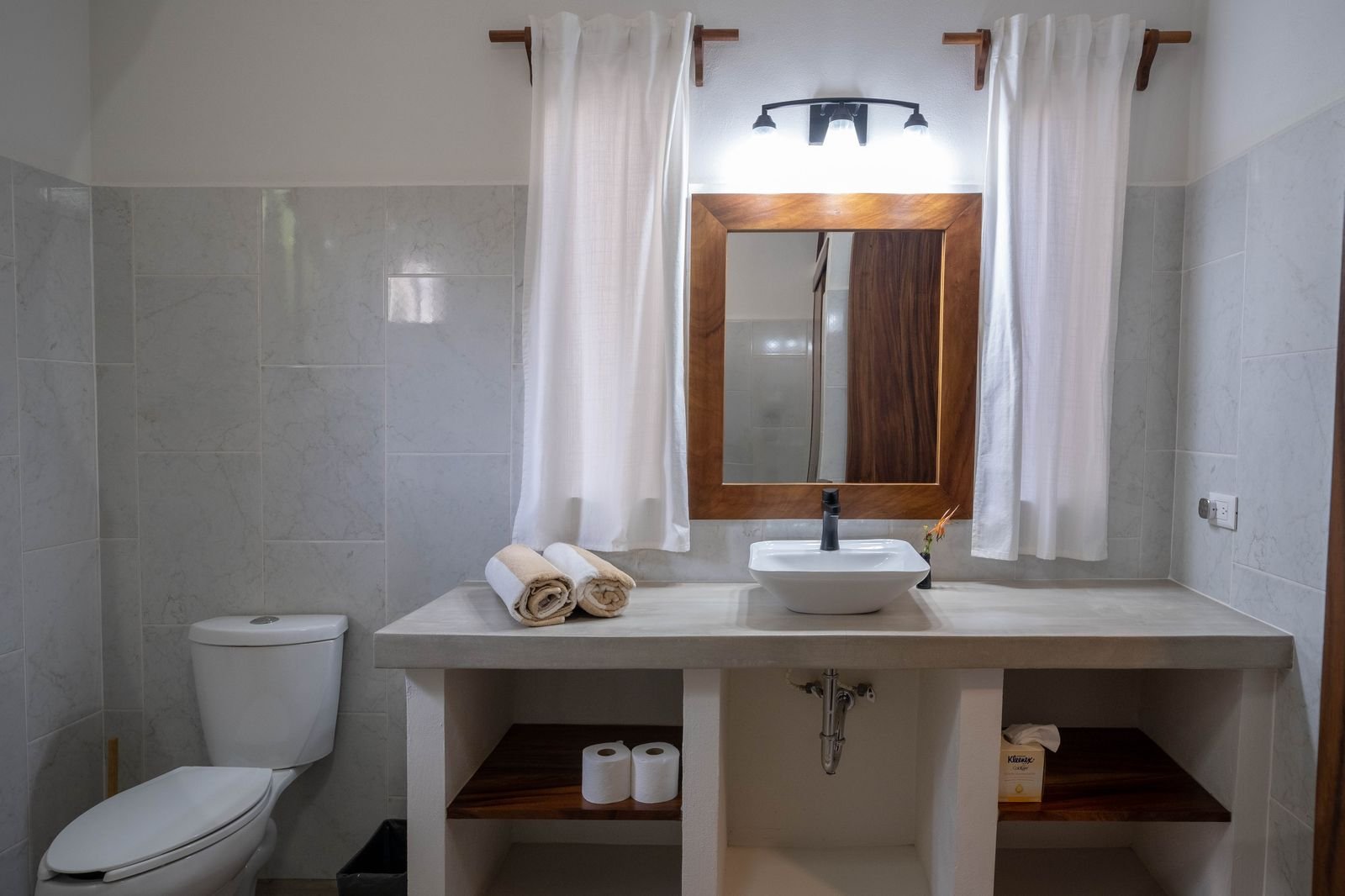 Bathroom at Casa Nisha with concrete vanity and parota wood mirror