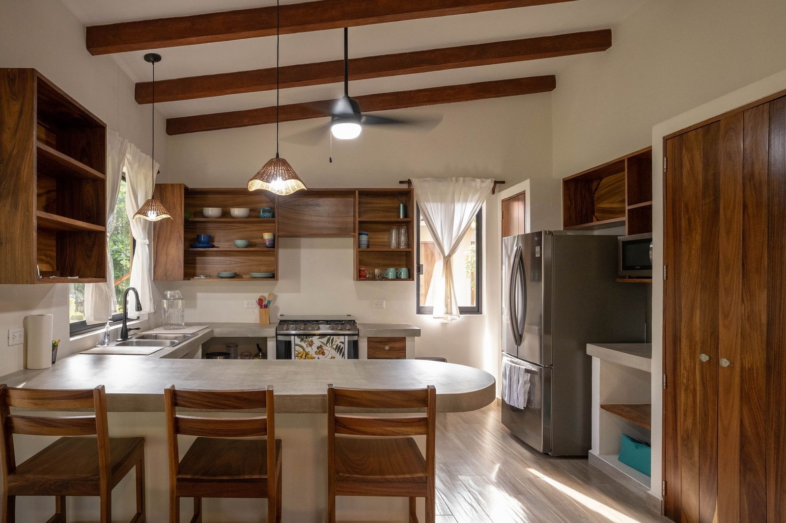 Casa Nisha kitchen with concrete countertops, parota wood shelving and exposed beams